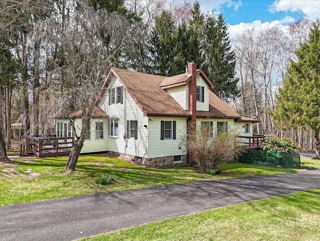 253 Thomas Rd, Blakeslee, PA 18610 - view of front of property featuring a chimney, a wooden deck, a front yard, and roof with shingles