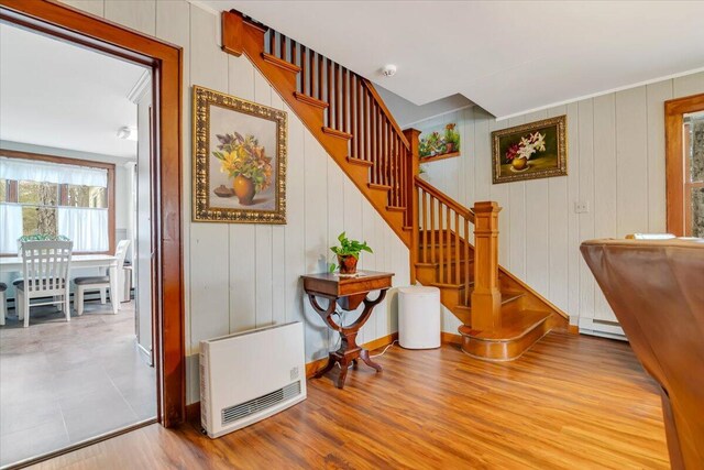 253 Thomas Rd, Blakeslee, PA 18610 - stairs with heating unit, a baseboard heating unit, wood finished floors, and baseboards