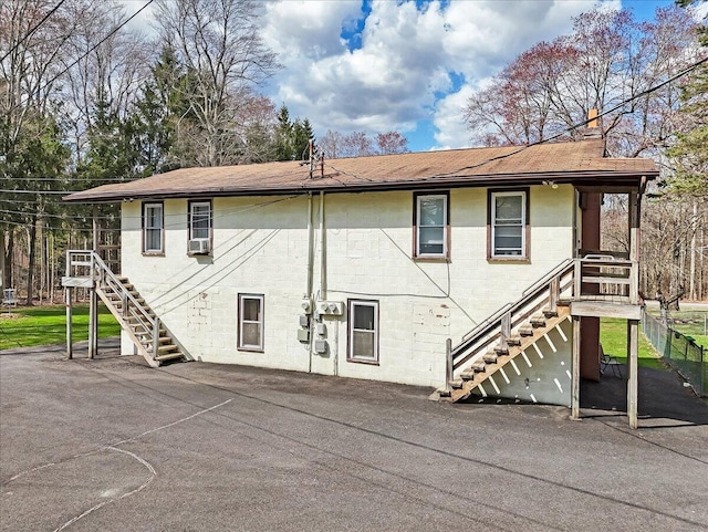253 Thomas Rd, Blakeslee, PA 18610 - rear view of house with stairway, a shingled roof, and concrete block siding