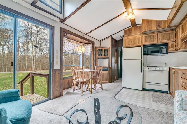 253 Thomas Rd, Blakeslee, PA 18610 - kitchen with white appliances, light carpet, brown cabinets, light countertops, and wooden walls