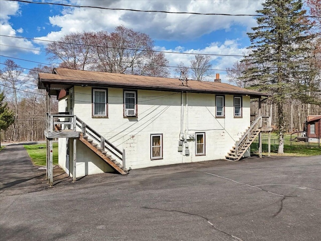 253 Thomas Rd, Blakeslee, PA 18610 - rear view of house with stairway, a chimney, and cooling unit