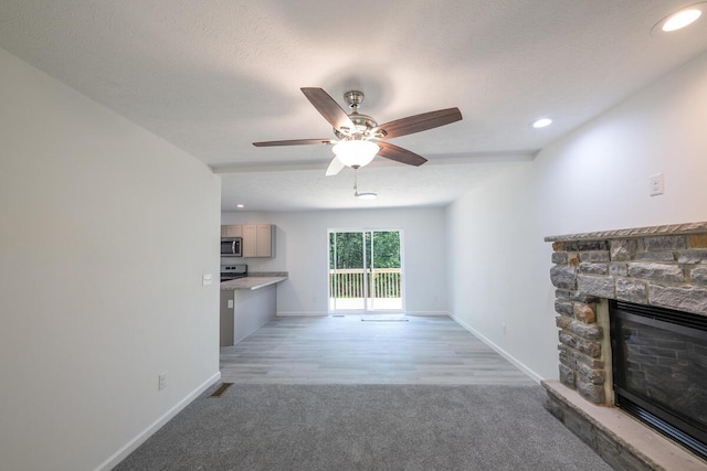 4105 Arbutus Dr Unit 1200, Tobyhanna, PA 18466 - unfurnished living room with light colored carpet, a stone fireplace, baseboards, ceiling fan, and recessed lighting