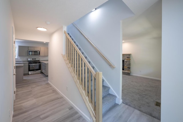 4105 Arbutus Dr Unit 1200, Tobyhanna, PA 18466 - stairs featuring a stone fireplace, wood finished floors, and baseboards