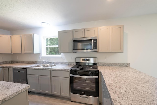 4105 Arbutus Dr Unit 1200, Tobyhanna, PA 18466 - kitchen featuring appliances with stainless steel finishes, a sink, light countertops, gray cabinetry, and light wood finished floors
