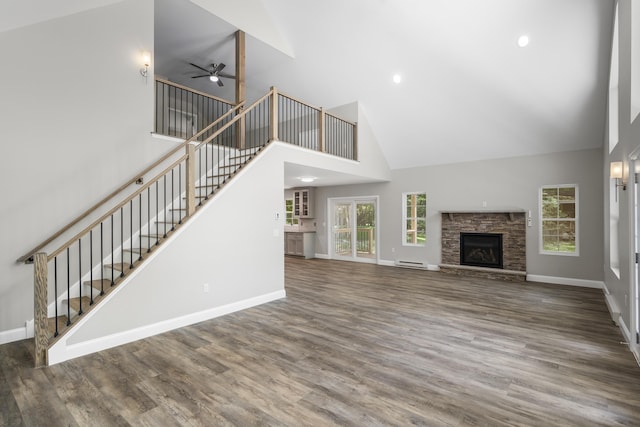 21 Wilde Gln, Albrightsville, PA 18210 - unfurnished living room featuring high vaulted ceiling, stairway, a baseboard radiator, a ceiling fan, and wood finished floors