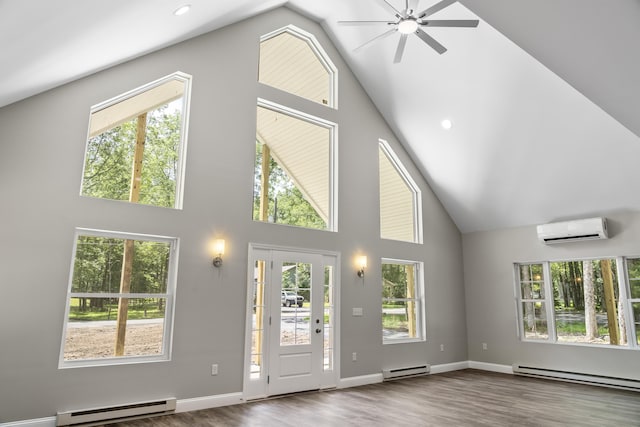 21 Wilde Gln, Albrightsville, PA 18210 - unfurnished living room with a baseboard heating unit, high vaulted ceiling, a wall unit AC, a ceiling fan, and healthy amount of natural light
