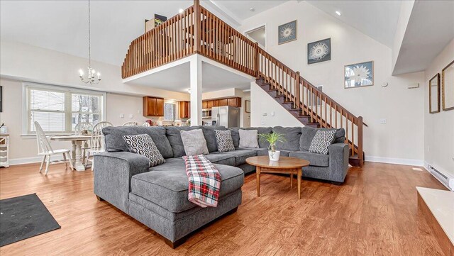 186 Brier Crest Rd, Blakeslee, PA 18610 - living room with high vaulted ceiling, a chandelier, light wood-type flooring, baseboards, and stairs