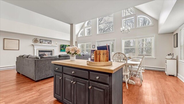 186 Brier Crest Rd, Blakeslee, PA 18610 - kitchen featuring light wood-style floors, high vaulted ceiling, butcher block countertops, a baseboard radiator, and a kitchen island