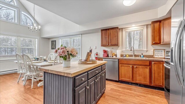186 Brier Crest Rd, Blakeslee, PA 18610 - kitchen with appliances with stainless steel finishes, a sink, light wood-style floors, brown cabinetry, and decorative light fixtures