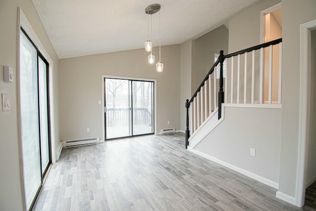 interior space with a baseboard radiator, lofted ceiling, a wealth of natural light, and wood finished floors
