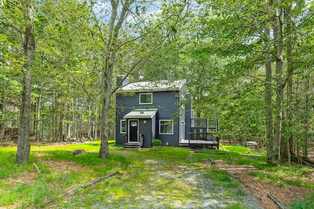 rear view of house featuring a wooden deck and entry steps