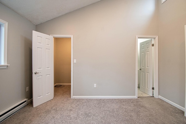 unfurnished bedroom with a baseboard radiator, lofted ceiling, carpet flooring, and baseboards