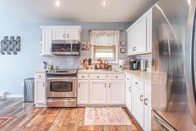 6435 Marvin Gdns, Tobyhanna, PA 18466 - kitchen featuring stainless steel appliances, a sink, light wood-type flooring, decorative backsplash, and light countertops