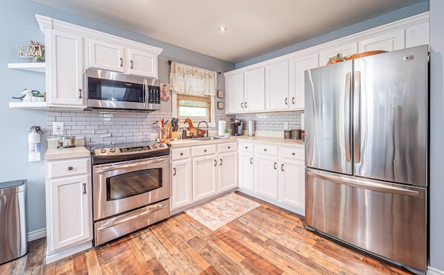 6435 Marvin Gdns, Tobyhanna, PA 18466 - kitchen featuring stainless steel appliances, light countertops, open shelves, white cabinetry, and light wood-style flooring