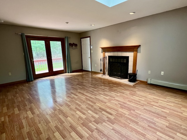 125 Ponder Ln, Scotrun, PA 18355 - unfurnished living room featuring light wood-style flooring, baseboards, a tile fireplace, recessed lighting, and a skylight