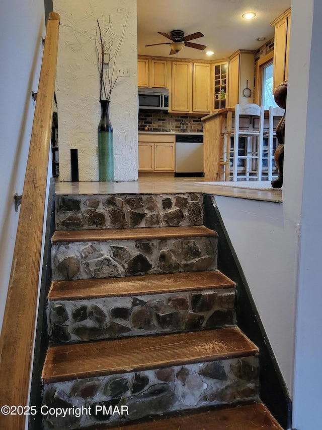 staircase with a ceiling fan and recessed lighting