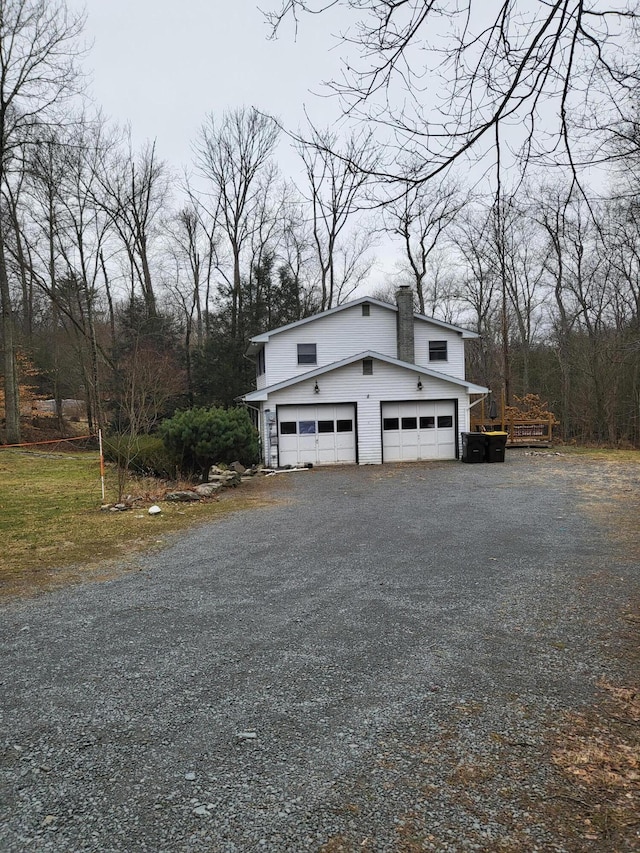 view of home's exterior featuring a garage and a chimney