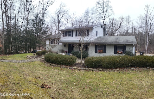 traditional-style home with brick siding and a front yard