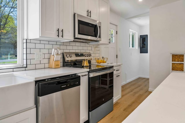 19 Mckinley Ln, Albrightsville, PA 18210 - kitchen with appliances with stainless steel finishes, tasteful backsplash, light countertops, white cabinets, and light wood finished floors