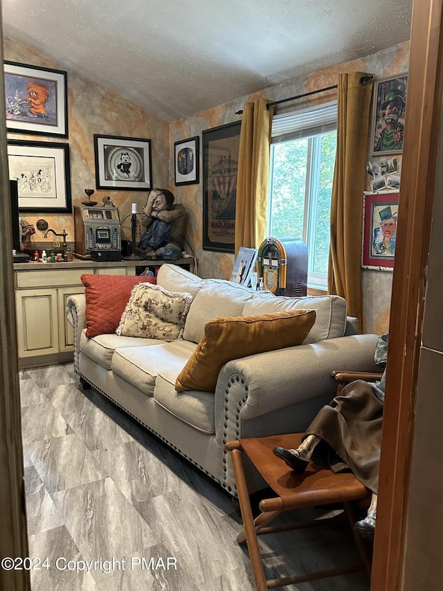 living room with vaulted ceiling, marble finish floor, and a textured ceiling