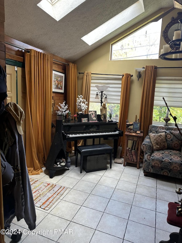 miscellaneous room with lofted ceiling with skylight, a textured ceiling, and light tile patterned floors