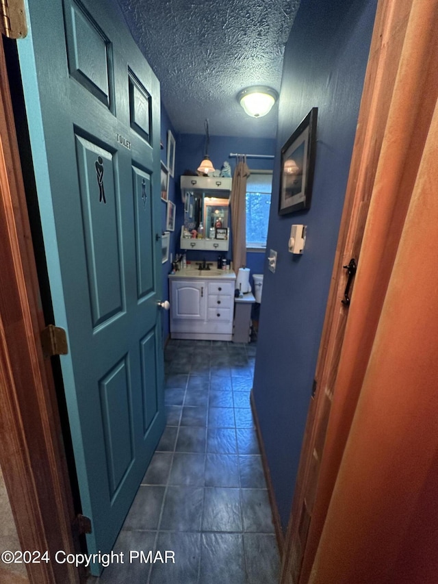 hallway with a textured ceiling