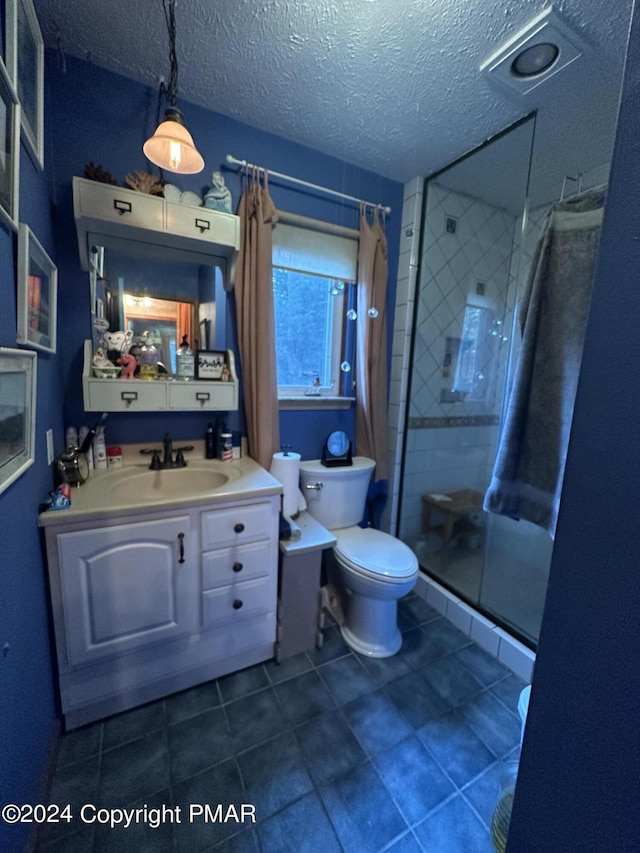 full bath with vanity, a shower stall, toilet, and a textured ceiling