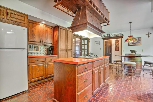 1163 Bush Rd, Cresco, PA 18326 - kitchen featuring freestanding refrigerator, a center island, stovetop, brown cabinets, and tasteful backsplash