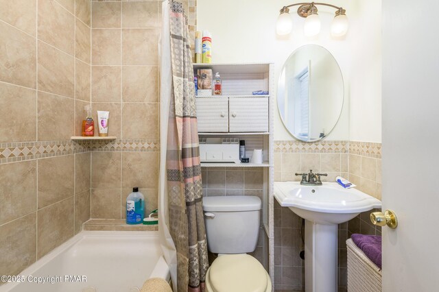 bathroom with sink, tile walls, backsplash, a shower with curtain, and toilet