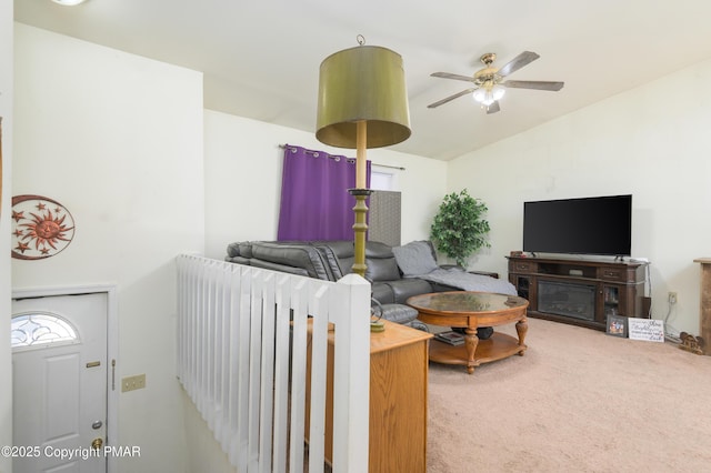 living room featuring ceiling fan, vaulted ceiling, and carpet