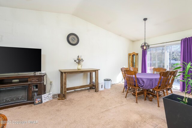 dining space featuring carpet flooring and vaulted ceiling