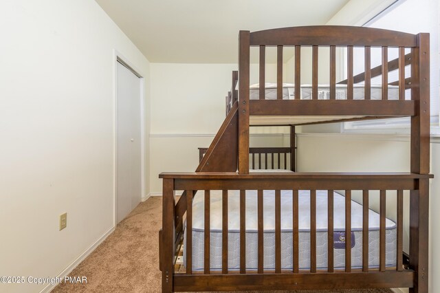 bedroom featuring light carpet and a closet