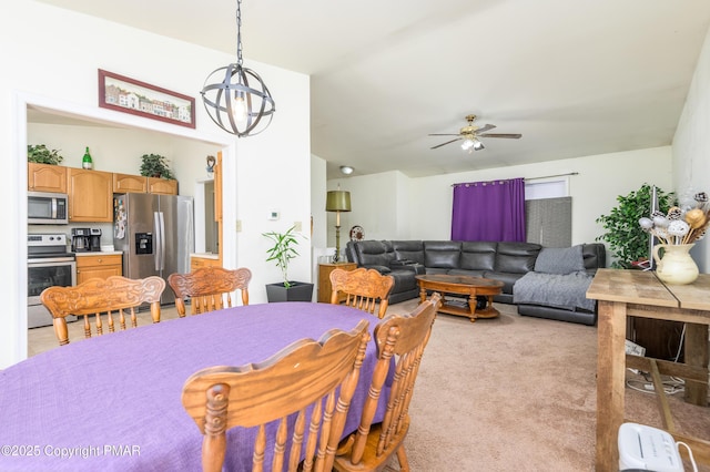 carpeted dining room featuring ceiling fan with notable chandelier