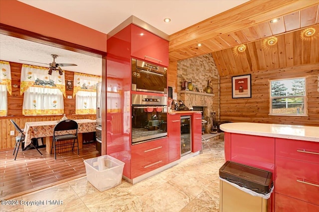 kitchen with beverage cooler, wooden walls, a ceiling fan, wooden ceiling, and vaulted ceiling