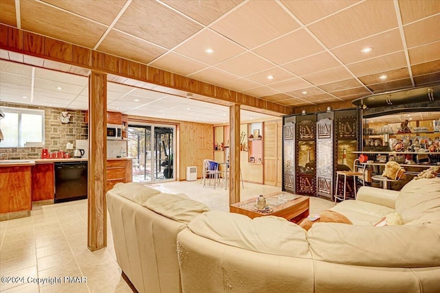 tiled living room with a paneled ceiling and wood walls