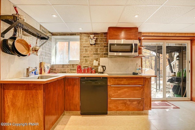 kitchen featuring a sink, light countertops, black appliances, tasteful backsplash, and brown cabinetry