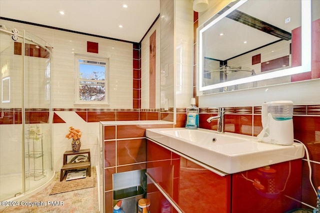 full bathroom with vanity, a shower stall, and tile walls