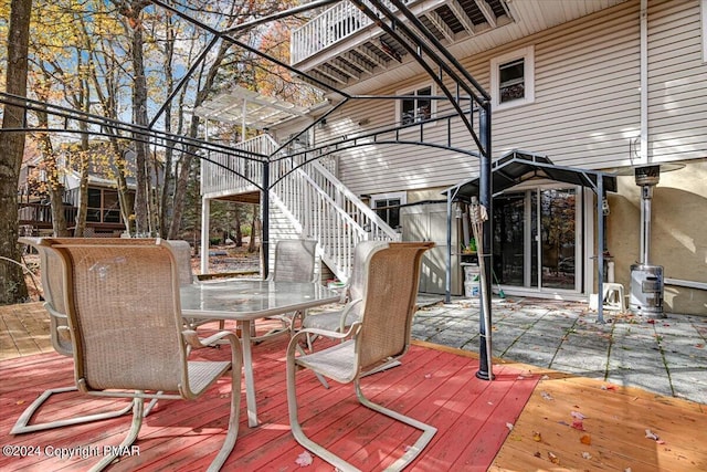 wooden terrace featuring outdoor dining area and stairway