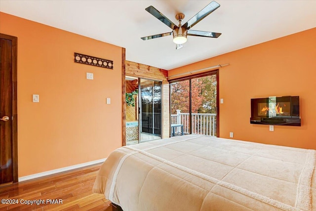 bedroom with baseboards, ceiling fan, wood finished floors, and access to exterior