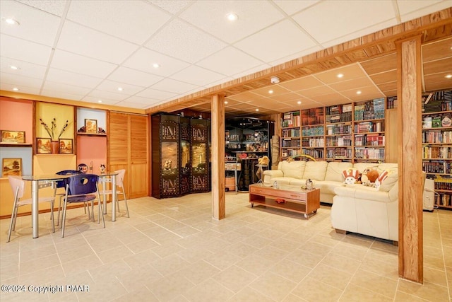 tiled living area with a paneled ceiling