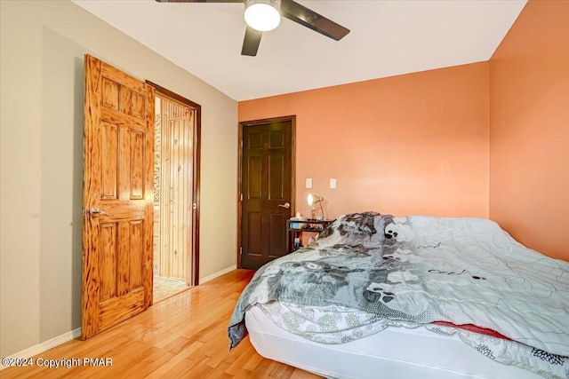 bedroom with baseboards, a ceiling fan, and light wood-style floors