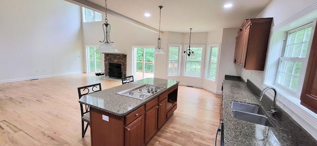 259 Great Bear Way E, Stroudsburg, PA 18302 - kitchen with white cooktop, light wood-style floors, healthy amount of natural light, a kitchen island, and high vaulted ceiling