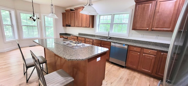 259 Great Bear Way E, Stroudsburg, PA 18302 - kitchen with appliances with stainless steel finishes, light wood-type flooring, a kitchen island, a breakfast bar area, and dark stone counters
