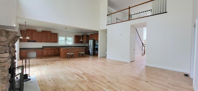 259 Great Bear Way E, Stroudsburg, PA 18302 - kitchen featuring stainless steel refrigerator with ice dispenser, a high ceiling, light wood finished floors, dark countertops, and a kitchen island