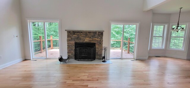 259 Great Bear Way E, Stroudsburg, PA 18302 - unfurnished living room featuring wood finished floors, a fireplace, healthy amount of natural light, and a high ceiling