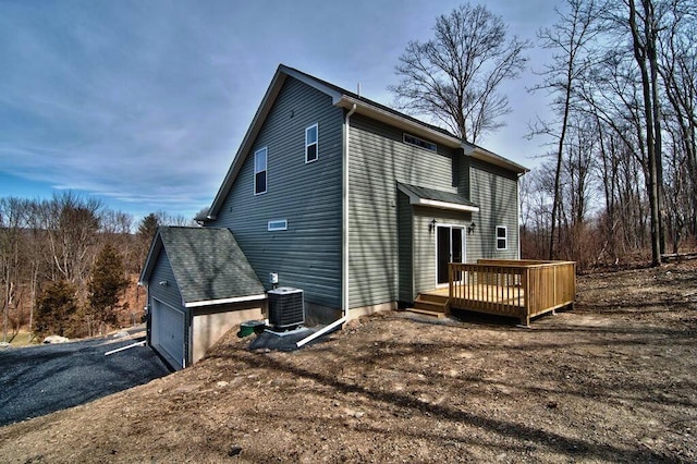 411 Pierce Ln, East Stroudsburg, PA 18301 - rear view of house featuring central AC unit, a deck, an attached garage, and driveway