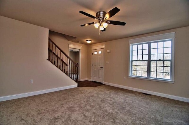 411 Pierce Ln, East Stroudsburg, PA 18301 - foyer entrance with stairs, dark colored carpet, a ceiling fan, and baseboards