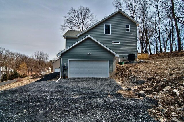 411 Pierce Ln, East Stroudsburg, PA 18301 - view of property exterior with gravel driveway, a garage, and central AC unit