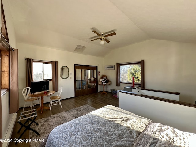 bedroom featuring a ceiling fan, multiple windows, vaulted ceiling, and wood finished floors