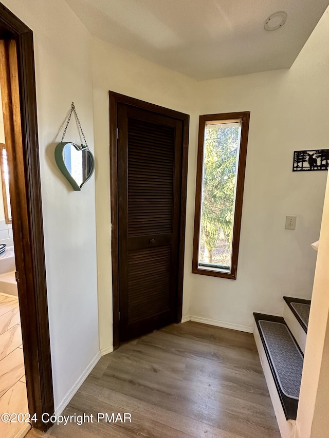 hall featuring baseboards and wood finished floors